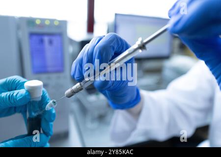 Scientifique injectant un échantillon via l'échantillonneur automatique du système HPLC. Chromatographie liquide haute performance en laboratoire chimique. Développement du pharmace Banque D'Images
