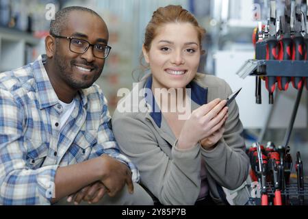 Portrait d'apprenti travaillant avec mécanicien sur machine à commande numérique Banque D'Images