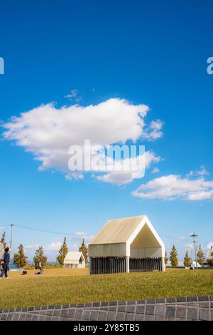 Cette photo capture une scène paisible au Sinri Holy Ground à Dangjin, avec une structure blanche simple sous un ciel bleu vif. Les nuages mous dérivent Banque D'Images