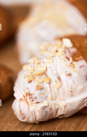 Délicieux croissants frais en glaçage sur plateau en bois, gros plan Banque D'Images