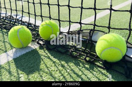 Balle de tennis jaune et verdâtre vif sur un court fraîchement peint Banque D'Images
