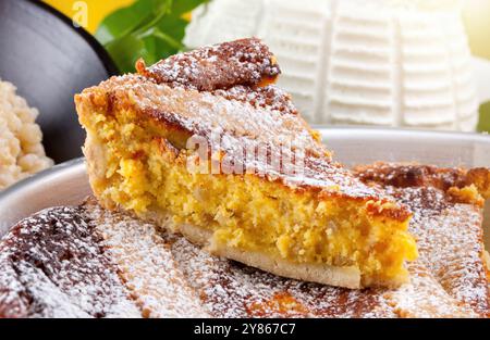 Tranche de gâteau napolitain pastiera saupoudrée de sucre glace avec garniture de fromage ricotta et une croûte tissée de panier Banque D'Images