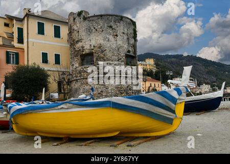 Bateaux de pêche sur la plage de la station balnéaire avec la Tour Baluardo, construite au 16ème siècle contre les attaques de pirates, Laigueglia, Ligurie, Italie Banque D'Images