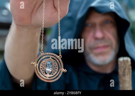 Un vieux moine avec une barbe tient une amulette de sablier dans sa main. Banque D'Images