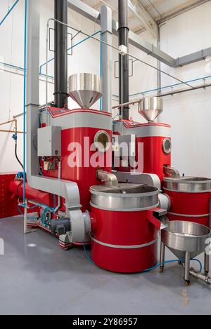 Le processus de torréfaction d'un lot de grains de café biologiques de haute qualité dans un grand torréfacteur industriel, Manizales, Colombie - photo stock Banque D'Images