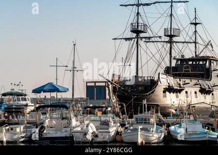 Grand bateau pirate noir amarré à côté de petits bateaux blancs à Ayia Napa, Chypre Banque D'Images