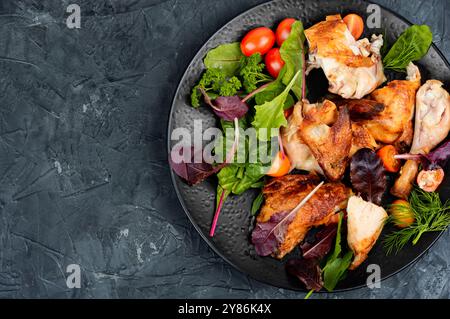 Morceaux de poulet rôti et salade. Pose à plat avec espace de copie. Banque D'Images