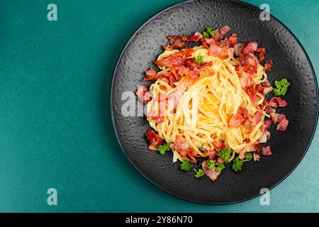 Pâtes classiques avec bacon frit sur une assiette, pâtes carbonara. Vue de dessus, espace de copie. Banque D'Images