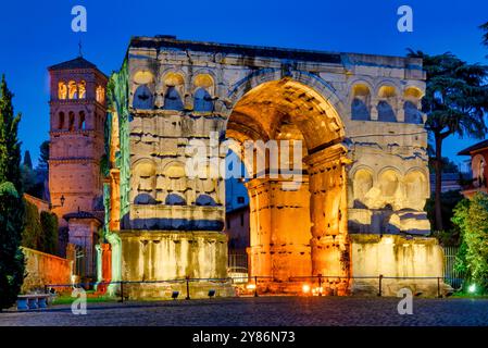 Arco di Giano et le clocher de San Giorgio in Velabro à Rome, Italie, illuminés au crépuscule. Banque D'Images