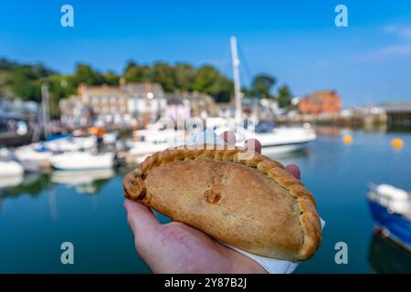 Délicieuse pâte de Cornouailles à la main, Harbour of Padstow en arrière-plan Banque D'Images