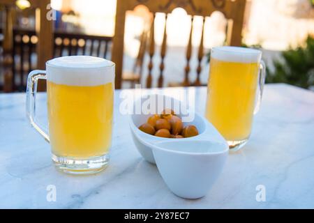 Apéritif espagnol : deux verres de bière et olives sur une terrasse. Espagne. Banque D'Images