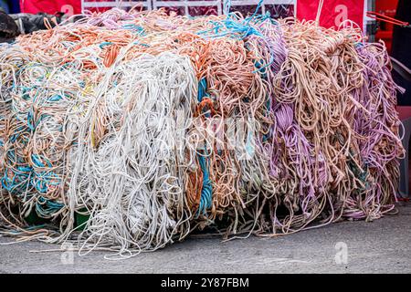 Ficelle colorée et chaotique de presse agricole sur une palette prête à être envoyée pour recyclage. Crédit John Rose/Alamy Banque D'Images