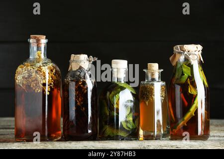 Différentes teintures dans des bouteilles sur une table en bois Banque D'Images