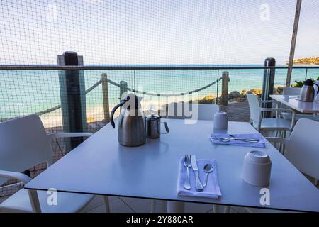 Salle à manger extérieure au restaurant en bord de mer à Aruba, avec des tables protégées par un filet pour garder les oiseaux à l'écart. Banque D'Images
