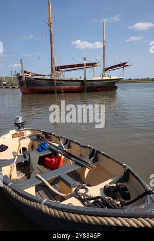 La barge à voile Thames Pioneer on Hard à Brightlingsea dont la coque est nettoyée à marée basse. avec son tendon classique dans le foerground. Banque D'Images