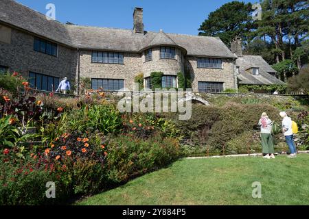 Visiteurs dans les jardins devant la maison à la propriété de la fiducie nationale Coleton Fishacre South Devon Angleterre Banque D'Images