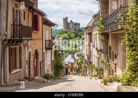 Rue principale dans le village de Najac, l'un des plus beaux villages de France, offrant une vue fantastique sur le château médiéval émergent, l'Aveyron, Banque D'Images