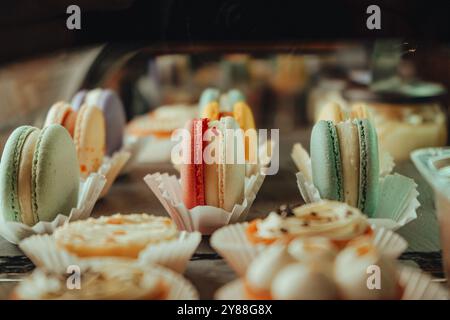Variété de macarons ou macarons exposés dans une vitrine de café. Désert français empilé par la couleur et les saveurs, populaire biscuit sucré à base de meringue Banque D'Images