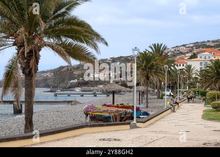 Les gens marchent le long de la plage dans la ville de Santa Cruz sur Madère. Banque D'Images