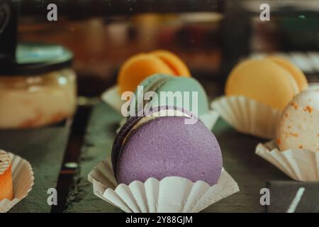 Variété de macarons ou macarons exposés dans une vitrine de café. Désert français empilé par la couleur et les saveurs, populaire biscuit sucré à base de meringue Banque D'Images