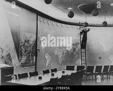 Carte météo pour les chefs d'état-major des États-Unis - la carte météo énorme sur un mur semi-circulaire dans la salle de présentation du bâtiment des chefs d'état-major des États-Unis combinés à Washington. Les horloges en haut de la carte indiquent l'heure de la journée dans toutes les parties du monde. Les conditions météorologiques sont projetées sur la carte comme souhaité. Il y a aussi des cartes sur les autres murs et sur les panneaux coulissants et pliants. 05 avril 1947.(photo par Interphoto News Pictures Inc.). Banque D'Images