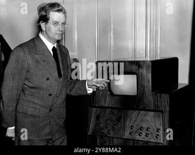 Télévision cette année -- M.J. L. Baird, avec l'un de ses derniers modèles de récepteurs de télévision, photographié dans son bureau de Londres le 1er février. Sir Kingsley Wood, le ministre des postes a annoncé que la première station de radiodiffusion télévisuelle travaillera vers la fin de l'année. L'appareil sera fourni par Baird Television Co. et Marconi-E.M.I. Television co, tandis que la station sera gérée par la B.B.C. le 11 juillet 1945. (Photo d'Associated Press photo). Banque D'Images