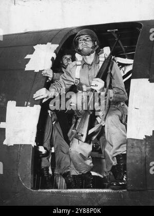 En entraînement de masse pour le combat - Lieut. Bill Howland se prépare à ***** Groupe de parachutistes de l'armée américaine dans un saut d'entraînement de ***** avion de transport. Sauter est la partie la plus facile du ***** parachutistes. Leur plus gros travail est d'assembler après ***** . Les troupes de parachutistes des États-Unis sont en Grande-Bretagne depuis un certain temps, bien que leur présence n'ait été que ***** Fait connaître par le lieutenant-général Dwight D. Eisenhower commandant des forces armées américaines sur le théâtre européen. ***** les troupes sont aujourd'hui engagées dans des manœuvres de masse-cartographie ***** attaques, pratique des sauts rapides, échange ***** Avec les Britanniques. Ceci Banque D'Images