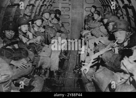 Yank ***** - Fumant, bavardant, souriant ou simplement assis enveloppés de pensées, les parachutistes américains, lourdement armés, survolent le canal anglais Enroute pour jouer un rôle clé dans l'invasion de la France le 6 juin en atterrissant à l'intérieur des terres du front de 100 milles le long de la côte normande. 06 juin 1944. (Photo d'Associated Press Radiophoto). Banque D'Images