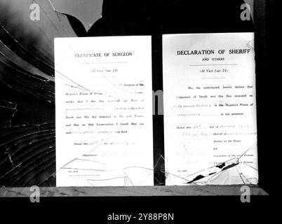 Un gros plan du panneau d'affichage, c'est la façade en verre brisée. Un avis est signé par le chirurgien de la prison et l'autre par le shérif de Surrey dans lequel la prison est réputée être située. La foule se rassemble à la porte de la prison de Wandsworth, Londres aujourd'hui 28 janvier alors qu'un avis officiel est posté concernant la mort de Bentley (pour le meurtre du policier Sydney Miles à Croydon. Les tentatives pour obtenir un sursis se sont poursuivies jusqu'aux premières heures du matin. La foule a brisé le verre de l'étui à avis, et deux hommes ont été arrêtés pendant des bagarres. 28 janvier 1953. (Photo d'Associated Press photo). Banque D'Images