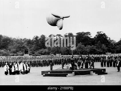 Le roi présente les couleurs au régiment de parachutistes lors de la cérémonie d'Aldershot -- la scène sur le terrain de parade à Aldershot, comme le roi, sur le dais (à droite) présente les couleurs au régiment de parachutistes. Également sur le dais, (avec retour à la caméra) est Field - Marshal Lord Montgomery. Un Blimp plane au-dessus. Un honneur rare a été accordé au Régiment de parachutistes aujourd’hui (mercredi), lorsque le roi, accompagné de la reine, a remis au Régiment ses premières couleurs lors d’une cérémonie qui a eu lieu ici. Le roi ne présente normalement pas de couleurs à un régiment dont il n'est pas colonel en chef. 19 juillet 1950. Banque D'Images