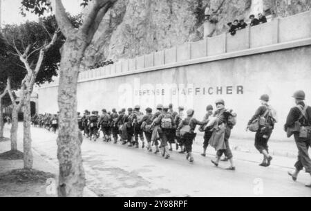 Les marins français observent les Américains ***** -- du haut d'un mur portant le signal français signifiant 'Post no bill'. Les marins français regardent les troupes américaines marcher dans une rue d'Oran, en Algérie, pendant l'occupation. 26 novembre 1942. (Photo de AP Wirephoto). Banque D'Images