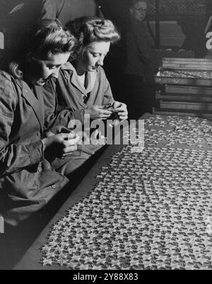 Grève des étoiles de la campagne -- des travailleuses de la monnaie royale emballent les médailles terminées, aujourd'hui, mercredi. La grève de la campagne pour le service dans la guerre a commencé à la Royal Mint et est sur le point d'être commencée dans la Royal Ordnance Factory. Les designs pour huit prix, le 1939-1945 Star, Atlantic, Air Crew, Europe, Afrique, Pacifique, Birmanie, Italie, France et Allemagne étoiles, ont été préparés à la monnaie royale et ont été approuvés par sa Majesté. 13 mars 1946. (Photo de Reuterphoto). Banque D'Images