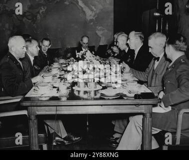 Militaires, chefs civils échange Notes -- échange d'informations entre les chefs militaires et civils dans l'effort de guerre sont ces hommes, photographiés lors d'un déjeuner à Washington, DC, le 8 décembre : (de gauche à droite autour de la table) Lt. Gen. Henry H. Arnold (de retour à la caméra) commandant général des forces aériennes de l'armée américaine ; amiral Emory S. Land, président de la Commission maritime américaine amiral William D. Leahy, chef d'État au président du président Roosevelt ; Paul V. McNutt, commission de la main-d'œuvre de guerre ; amiral E. J. King, commandant en chef de la flotte américaine et chef des opérations navales, et Donald Nelson, président, Banque D'Images