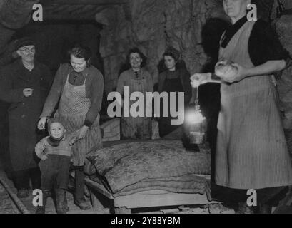 Des civils allemands prennent refuge dans des tunnels alors que l'offensive des bombardiers alliés explose Reich : une section de l'abri de la mine de Rilchingen. Les hommes, les femmes et les enfants de Rilchingen, ville allemande de l'autre côté de la Sarre, au nord de Sarreguemines, se sont installés dans des ouvrages en calcaire désaffectés près de chez eux, où ils mènent une existence souterraine, avec de la volaille, du bétail et d'autres animaux d'élevage, tandis que l'offensive alliée déchire le cœur du Reich. L'âge des troglodytes varie de plus de soixante-dix ans à moins de douze mois, et des ajouts encore plus jeunes à la population souterraine sont attendus. La seule lumière vient vers l'avant Banque D'Images