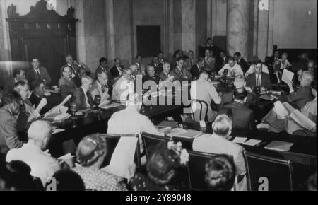 Le Comité sénatorial ouvre l'audience sur la Charte -- la grande salle du caucus du sénat au Capitole est emballée alors qu'Edward R. Stettinius, Jr., (tenant le papier, au centre à droite) ancien secrétaire d'État et leader à la conférence de San Francisco, ouvre aujourd'hui son témoignage sur la charte des Nations Unies à l'audience du Comité sénatorial des relations étrangères. Les membres du comité sont : (dans le sens des aiguilles d'une montre, en commençant par homme en combinaison légère, en bas à droite au centre) les sénateurs Alexander Wiley (R-W-S) Warren R. Austin (R-VT), Scott Lucas (d-ILL), Wallace H. White (R-me), Arthur H. Vandenberg (R-Mich), Robert M. Lafollette (P-Wis), Arthur Capper (R-Kans), Banque D'Images