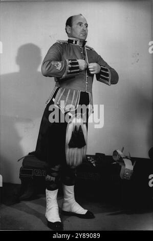 Le Bandmaster de la Black Watch enfile son uniforme de Gala --le Bandmaster enfonce sa tunique : sa couleur est rouge ; il a deux rabats latéraux sous lesquels il y a des poches. Notez l'insigne du maître d'orchestre sur la manche droite de Mr. Hick. Tunique, en rouge, a deux sidéflaps avec poches en dessous. 25 février 1951. (Photo de Tom L. Blau, Camera Press). Banque D'Images