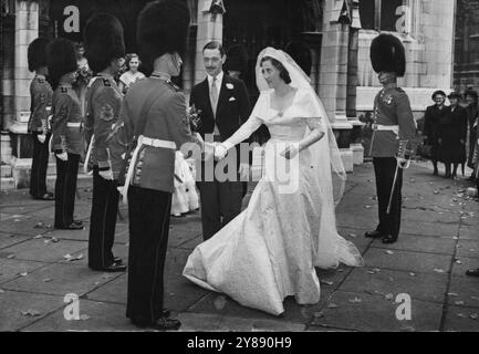 Un mariage pittoresque de Londres -- la mariée et le marié, quittant l'église, serrent la main aux sous-officiers, Grenadier Guards, qui formèrent la Garde d'honneur. Le mariage entre le capitaine David W. Hargreaves, Grenadier Guards, et Miss Judith Currie, fille du capitaine et MRS Bertram Currie, de Market Harborough, Leicestershire, a eu lieu à l'église Margaret's Church, Westminster. La lune de miel sera consacrée à une excursion automobile, avant de se rendre à Krefeld, en Allemagne, où le marié est stationné. 18 octobre 1951. (Photo de Sport & General Press Agency Limited.) Banque D'Images