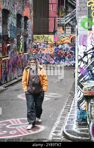 Un homme marchant dans Hosier Lane, une célèbre rue graffiti à Melbourne, en Australie Banque D'Images