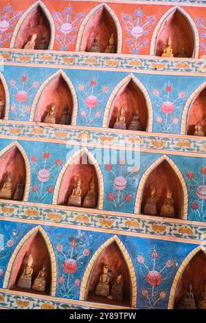 Bleu et rose, petites alcôves murales rouges avec petite statue de Bouddha à l'intérieur. Au Wat Sisaket à Vientiane, Laos Banque D'Images