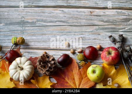 Belles feuilles jaunes d'automne, citrouilles blanches et pommes en gros plan sur un fond en bois. Espace de copie pour le texte. Banque D'Images