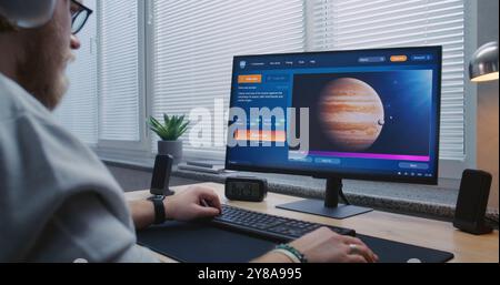 Homme adulte dans des écouteurs types de texte dans l'intelligence artificielle chatbot sur ordinateur personnel. Application générateur de vidéo AI générer une vidéo détaillée de Jupiter et sa lune. Création vidéo avancée générée par IA Banque D'Images