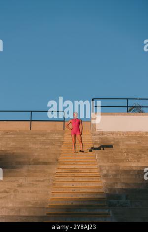 Forme athlète féminine debout sur la cage d'escalier pendant l'entraînement Banque D'Images