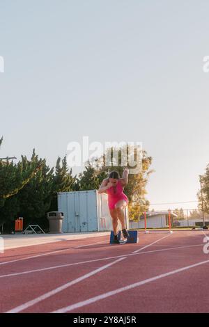 Athlète de piste féminine sprinte hors de blocs pendant l'entraînement Banque D'Images