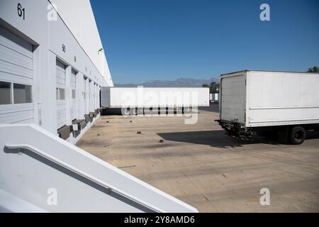 Remorque de camion de boîte blanche reculant dans la baie d'entrepôt de distribution Banque D'Images