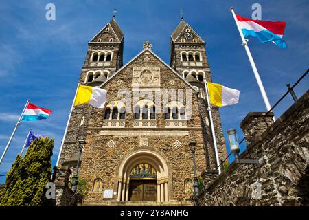 Église paroissiale catholique romaine à Clerf avec drapeau de l'église et drapeau du Luxembourg, Luxembourg, Clerf Banque D'Images