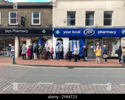 Egham, Surrey, Royaume-Uni. 3 octobre 2024. Les clients font la queue devant la pharmacie Jays à Egham, Surrey. C’est une période occupée pour les pharmaciens car le COVID, la grippe et le rhume font les rondes. Les patients éligibles reçoivent également leurs jabs de rappel COVID-19 et leurs jabs annuels contre la grippe. Crédit : Maureen McLean/Alamy Live News Banque D'Images