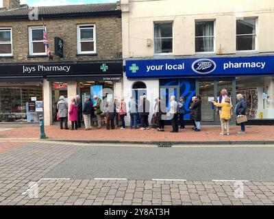 Egham, Surrey, Royaume-Uni. 3 octobre 2024. Les clients font la queue devant la pharmacie Jays à Egham, Surrey. C’est une période occupée pour les pharmaciens car le COVID, la grippe et le rhume font les rondes. Les patients éligibles reçoivent également leurs jabs de rappel COVID-19 et leurs jabs annuels contre la grippe. Crédit : Maureen McLean/Alamy Live News Banque D'Images