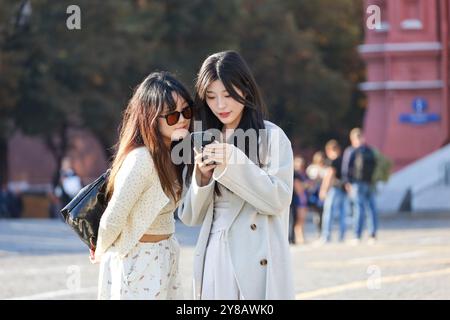 Deux filles asiatiques regardant l'écran de smartphone sur la rue de la ville Banque D'Images