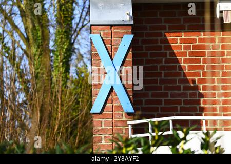 Croix bleue en bois comme signe de protestation contre la construction du tunnel Fehmarnbelt sur une maison à Haffkrug, Schleswig-Holstein, Allemagne, Blaues Hol Banque D'Images