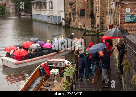 Belgique, Flandre, Bruges, Rosary Quay, Rozenhoedkaai, touristes sur le bateau d'excursion sous la pluie Banque D'Images